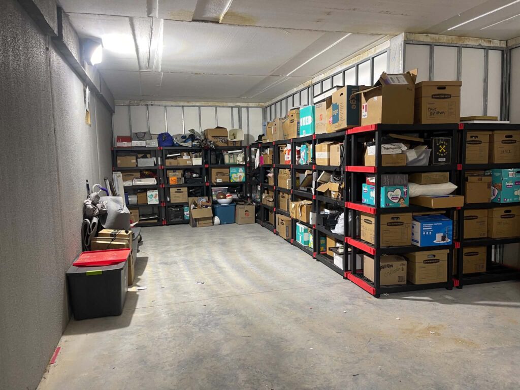The customer's kept boxes, bags and household belongings organized on rows of black storage shelving after the basement cleanout.