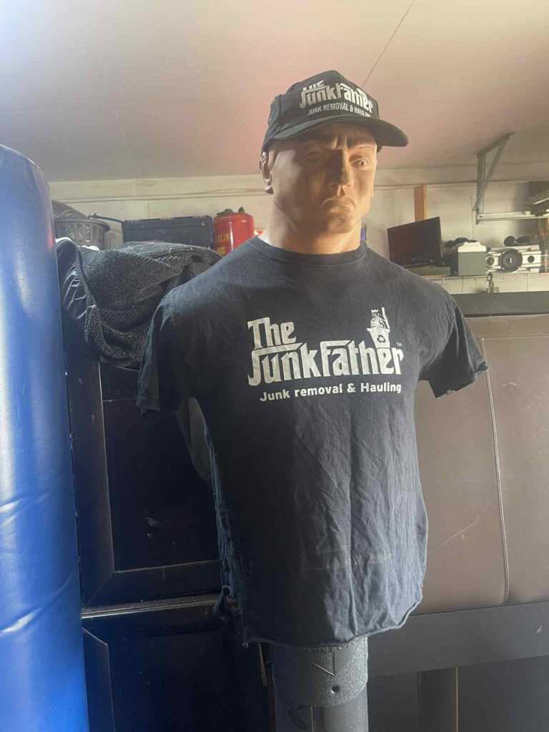 BOB punching dummy wearing a black JunkFather T-shirt and branded cap.