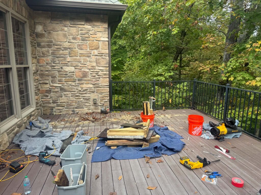 Dismantled grill-island framing and debris gathered on moving blankets before being carried away from the deck