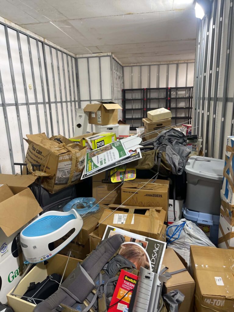 Plastic storage bins, bags, boxes and household items crowded together before the basement cleanout.