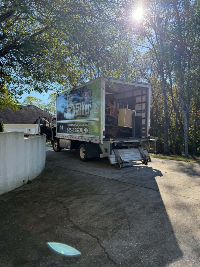 The JunkFather truck loaded with estate items beside the cleared driveway after pickup