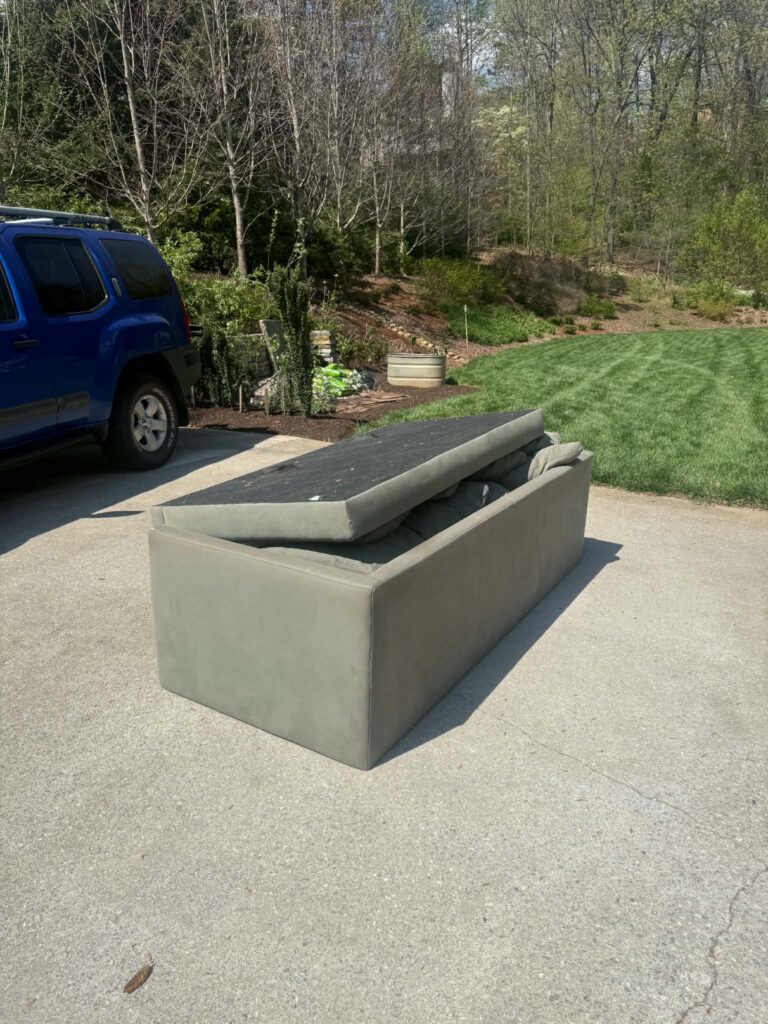 Couch placed on a driveway for furniture pickup