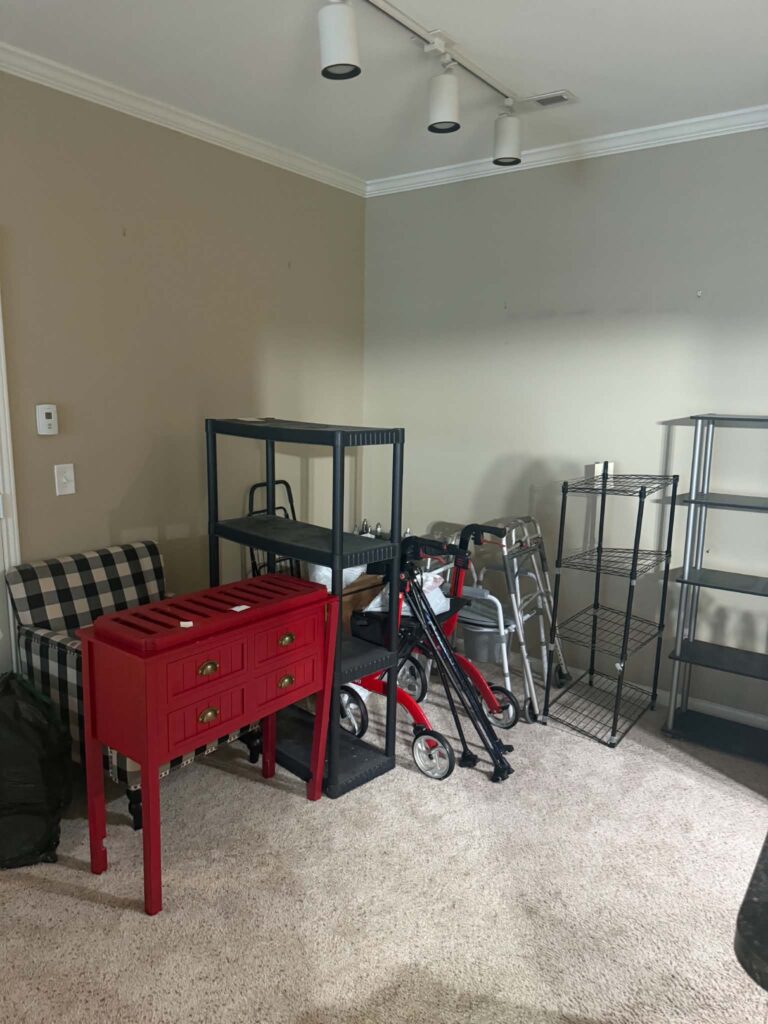 Furniture, shelving, and walkers inside a carpeted room at a Farragut move-out pickup.