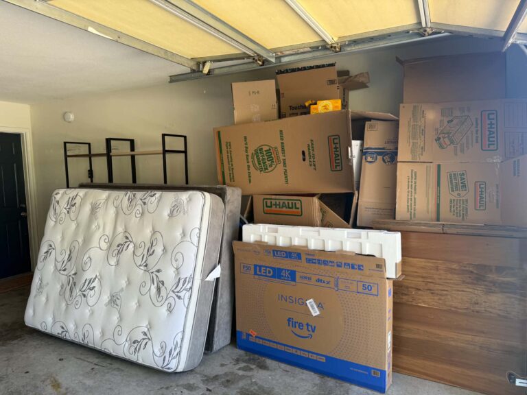 Mattress and cardboard moving boxes in an Oak Ridge garage before junk pickup.