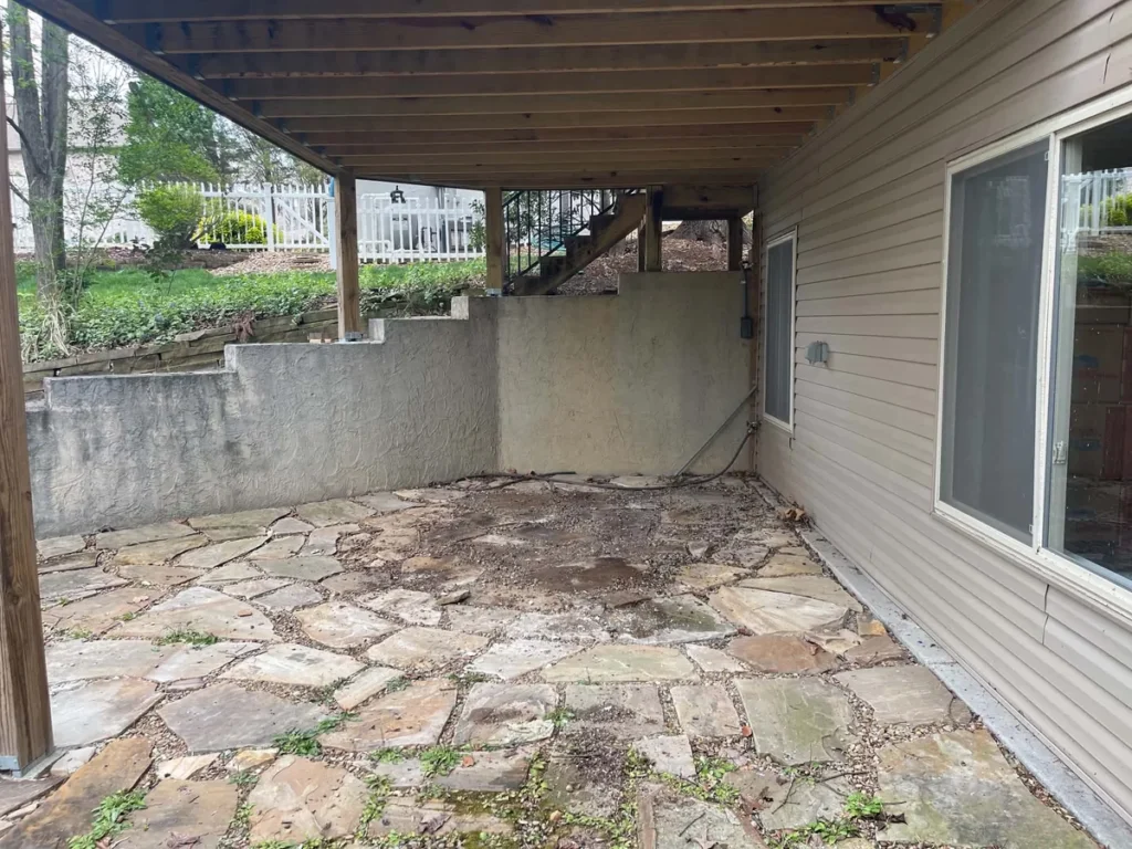 Stone patio beneath the same deck with the hot tub removed