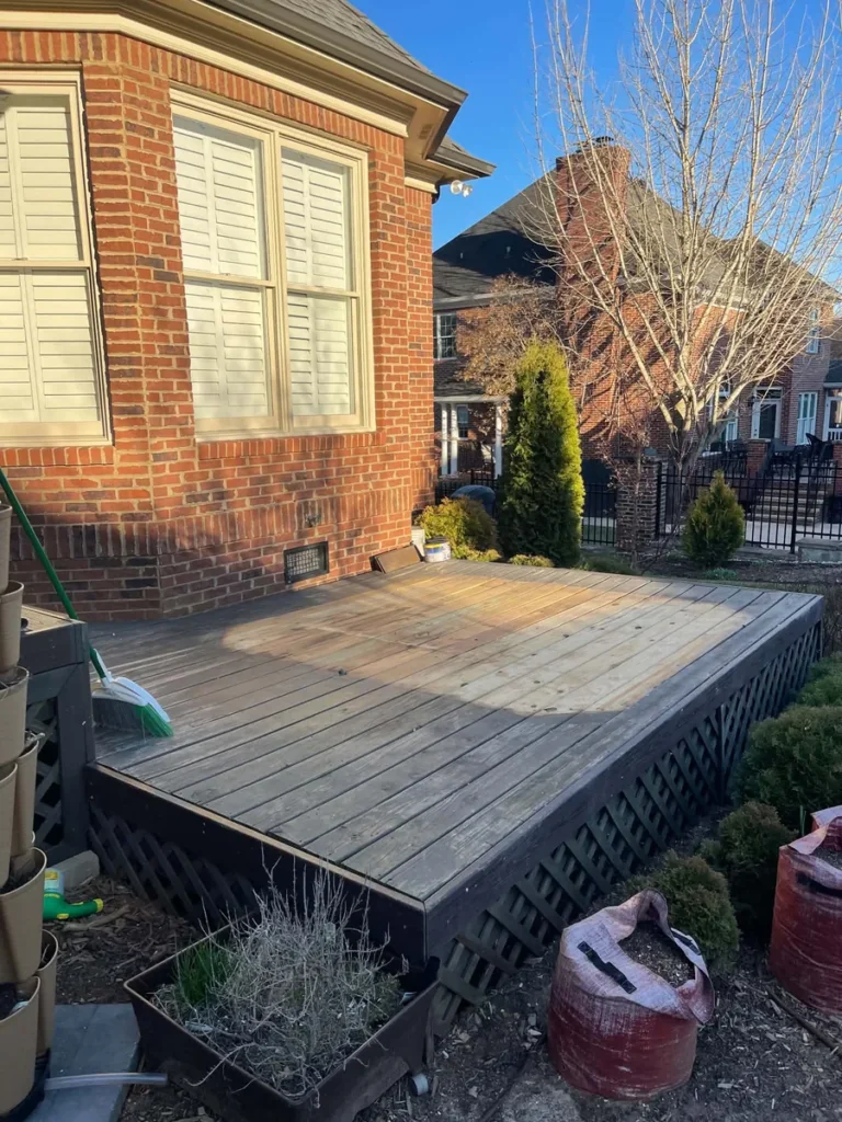 Raised wooden deck beside the same brick home after the hot tub was removed