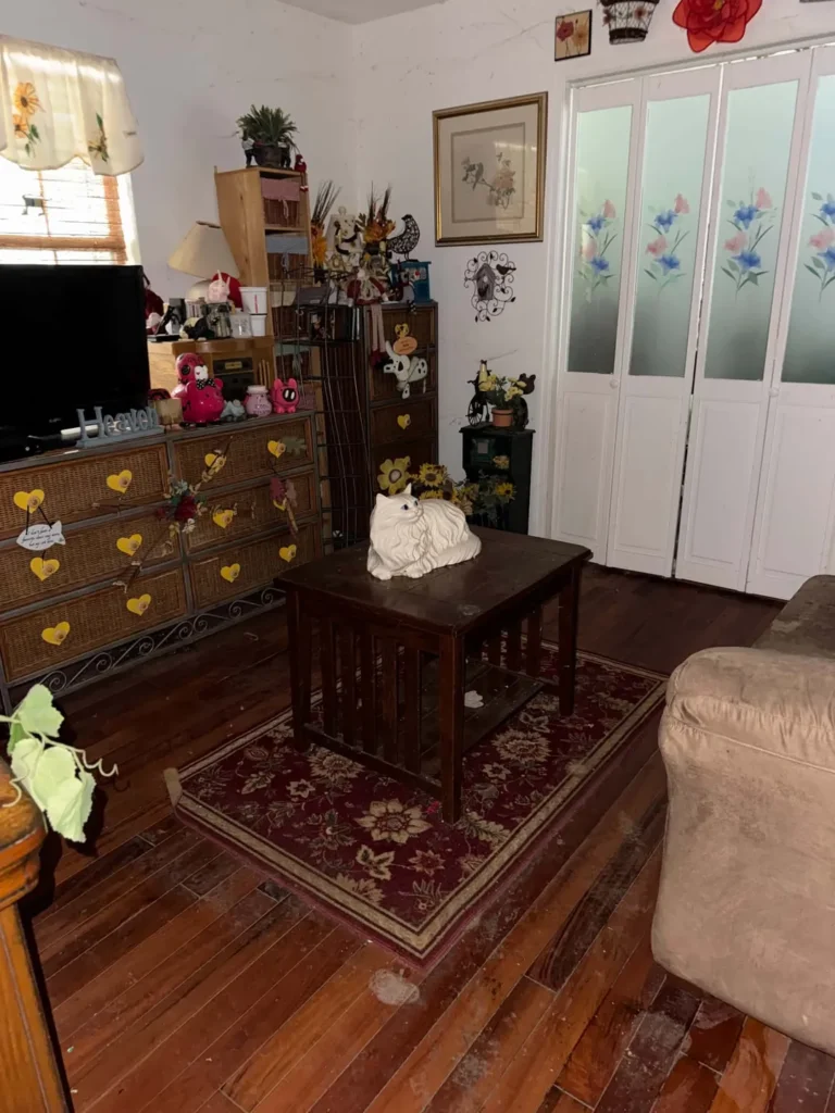 Living room after removal, showing open floor around the table and remaining furniture.