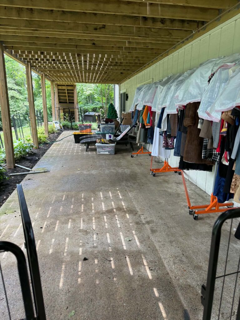 Under-deck area after selected unwanted items were hauled away, with clothing racks and storage bins remaining.